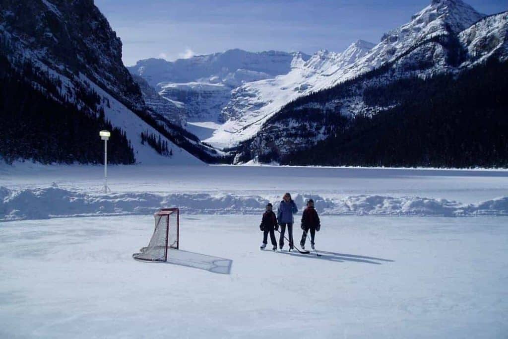 Family Playing Ice Hockey On Lake Louise Alberta Canada